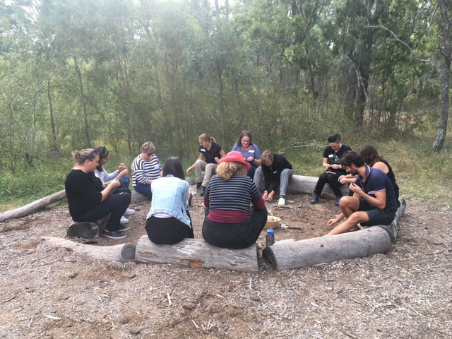 Outdoor workshop — teachers around a circle of logs